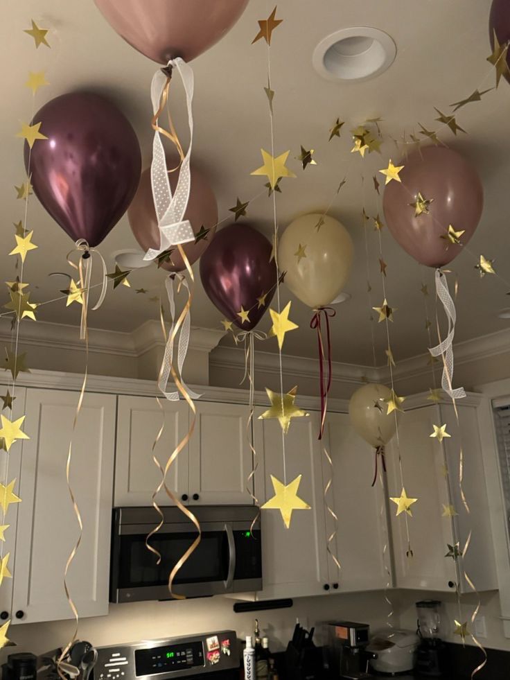 Mauve and gold birthday balloons with hanging star garlands